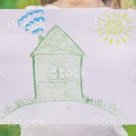 Drawing of a green house in the hands of a child. nature.l