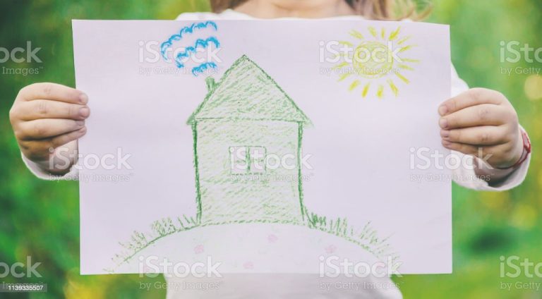 Drawing of a green house in the hands of a child. nature.l